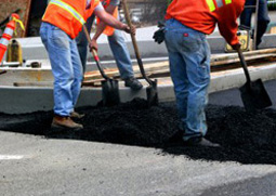 workers repairing asphalt in parking lot